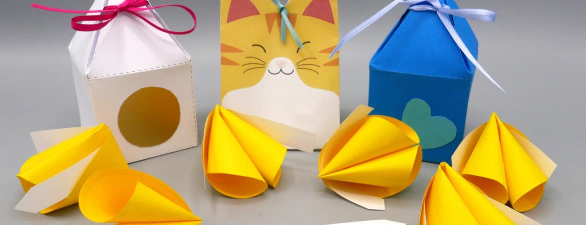 Glückskekse aus Papier mit kleinen Botschaften und dazu passende Boxen aus Papier