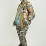 Skulptur aus Zeitungspapier: stehender Mann mit Gesichtsmaske, Bilder, Texte und Überschriften der Bildzeitung noch lesbar